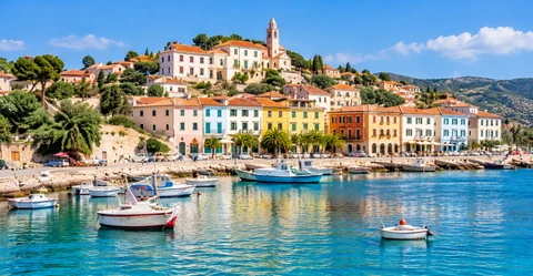 A colorful coastal town with fishing boats on clear blue water
